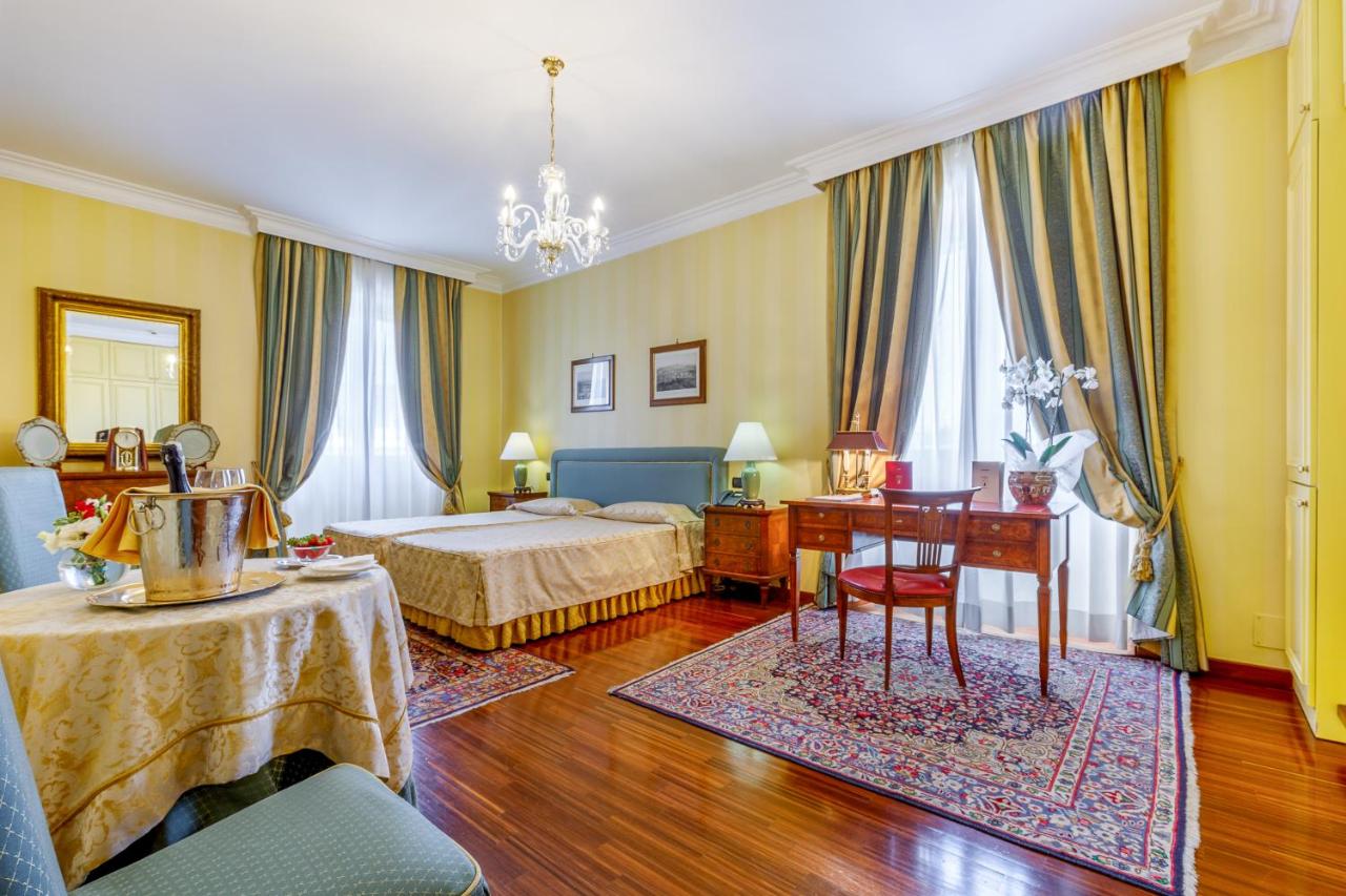 een hotelkamer met twee bedden en een bureau bij Residenza Paolo VI in Rome