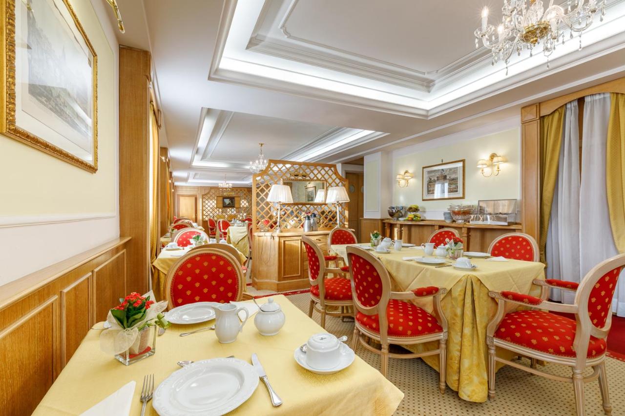 een restaurant met twee tafels en rode stoelen bij Residenza Paolo VI in Rome