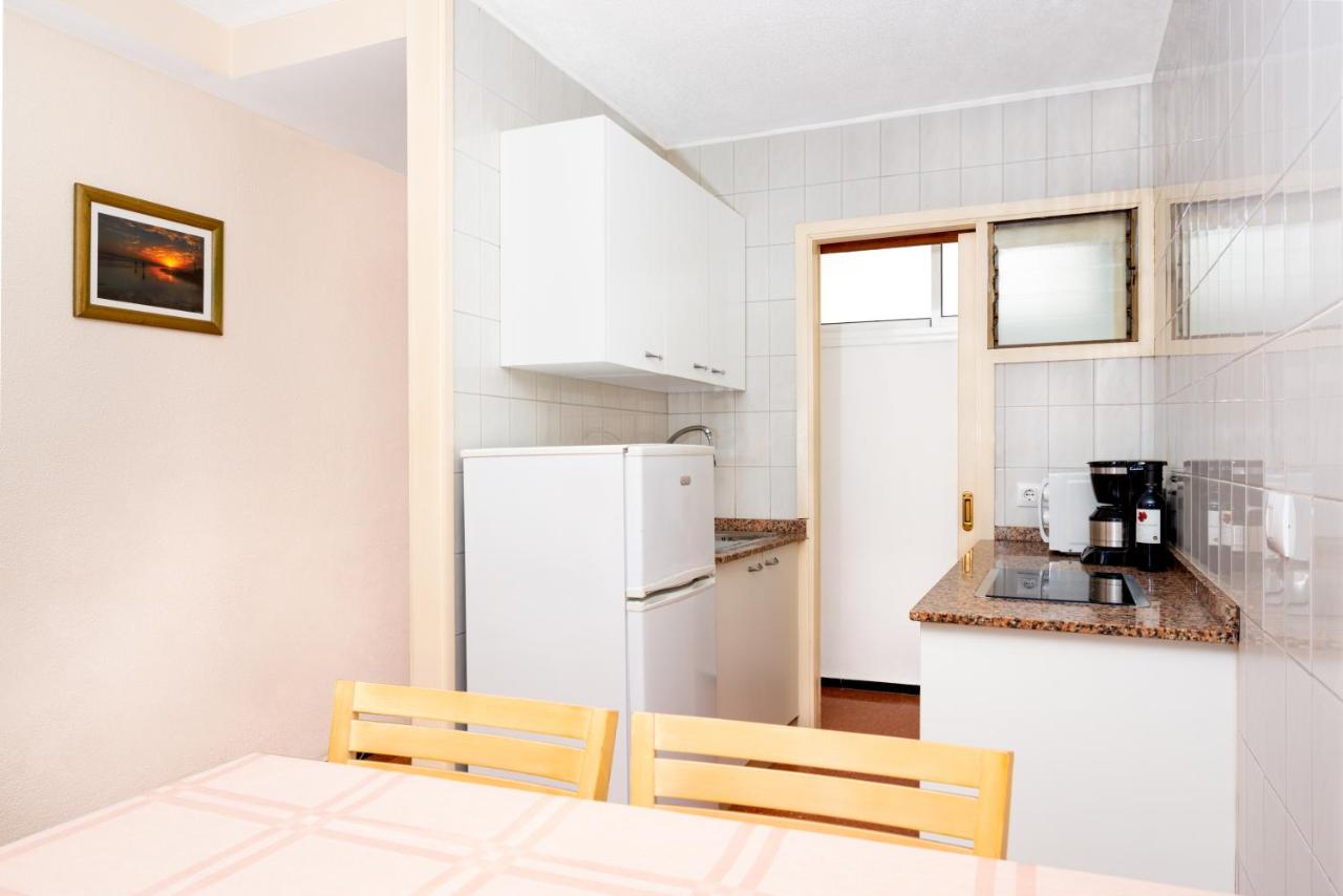 een keuken met een witte koelkast en een tafel met stoelen bij Apartamentos las Góndolas in Playa del Inglés