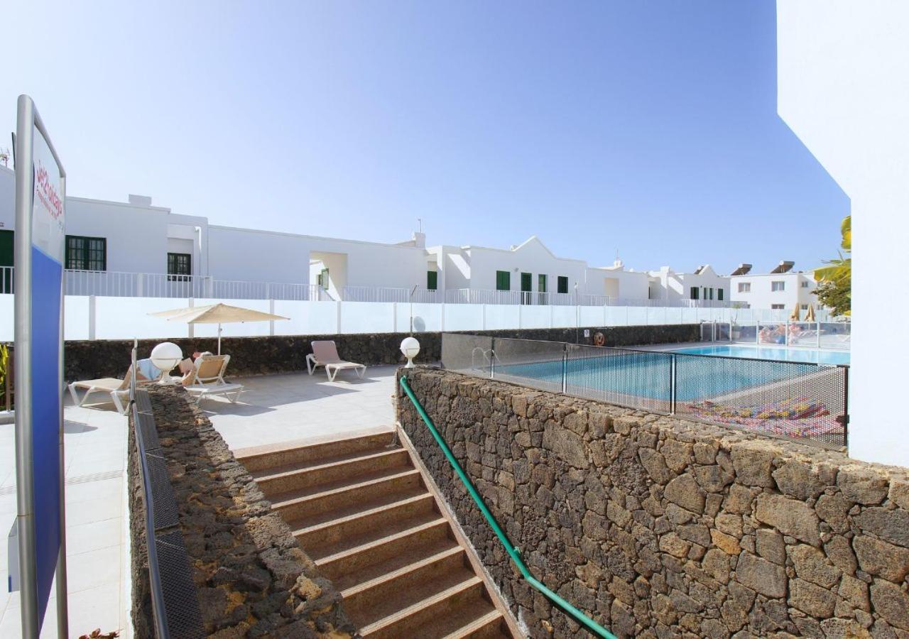 een resort met een zwembad en een stenen muur bij Apartamentos Aloe in Puerto del Carmen