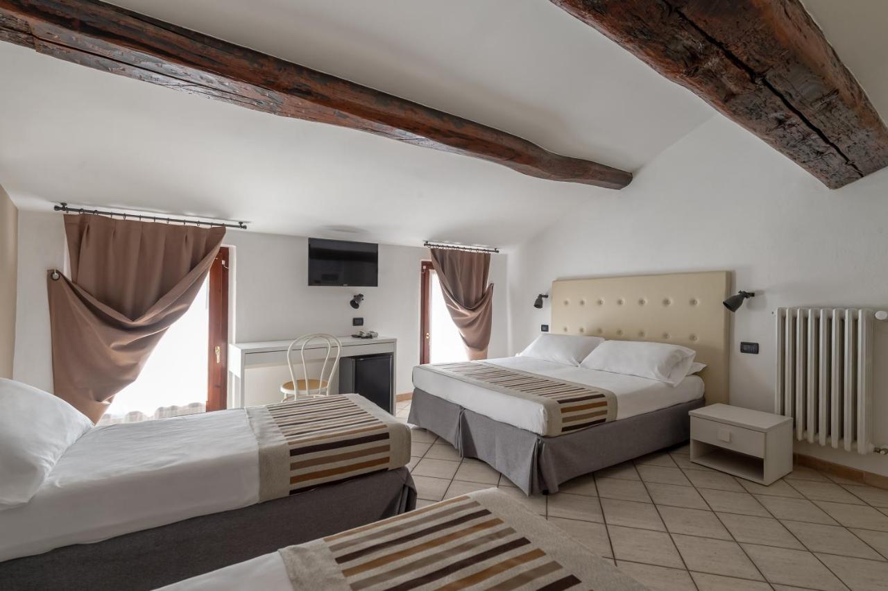 een hotelkamer met twee bedden en een televisie bij Hotel Mantegna Stazione, MantegnaHotels in Mantova