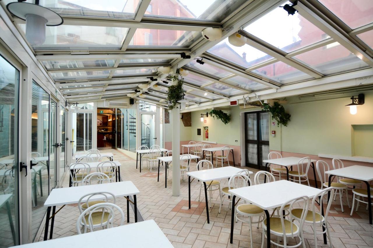 een leeg terras met tafels en stoelen bij een restaurant bij Hotel Mantegna Stazione, MantegnaHotels in Mantova