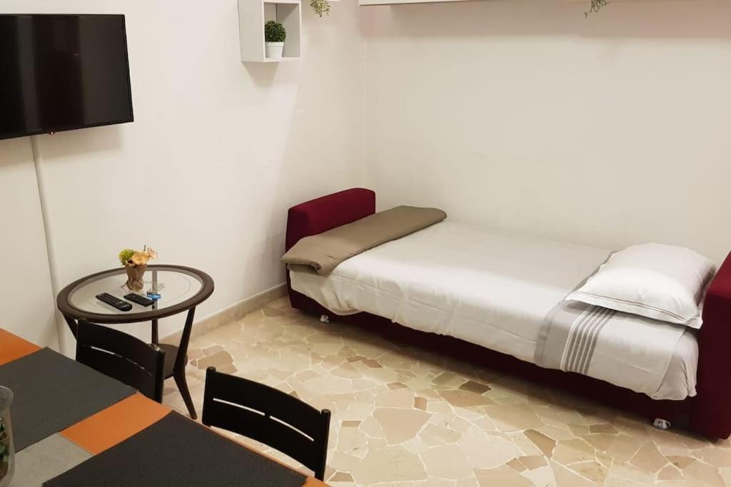 een kleine kamer met een bed, een tafel en een tv bij Air Bonghin Milano Accursio in Milaan