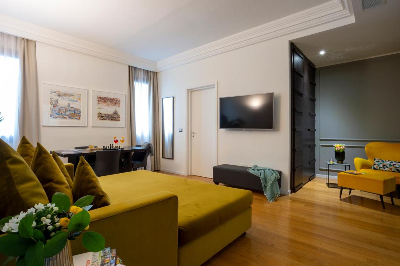 een woonkamer met een gele bank en een tv bij Elizabeth Lifestyle Hotel in Bologna