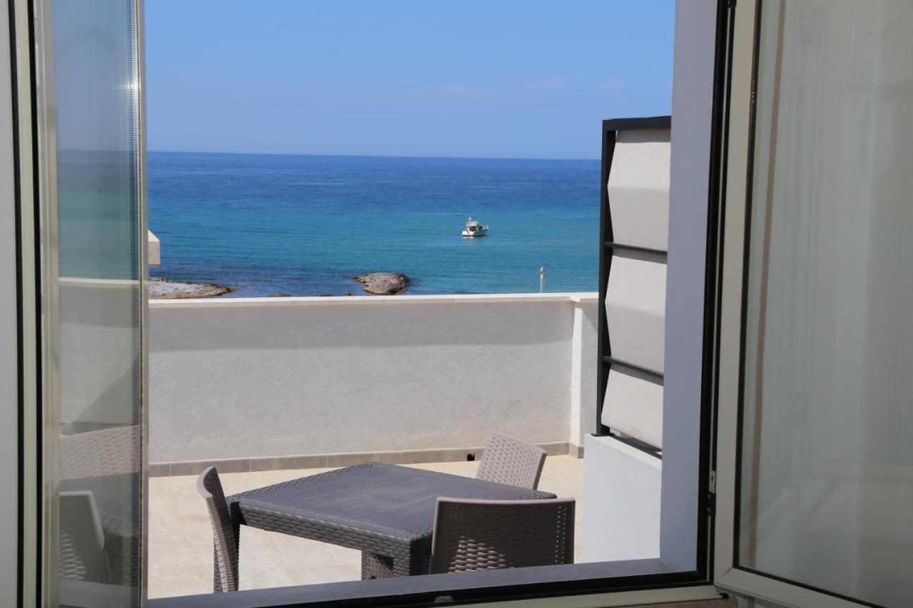 een balkon met een tafel en uitzicht op de oceaan bij Hotel Residence Ampurias in Castelsardo