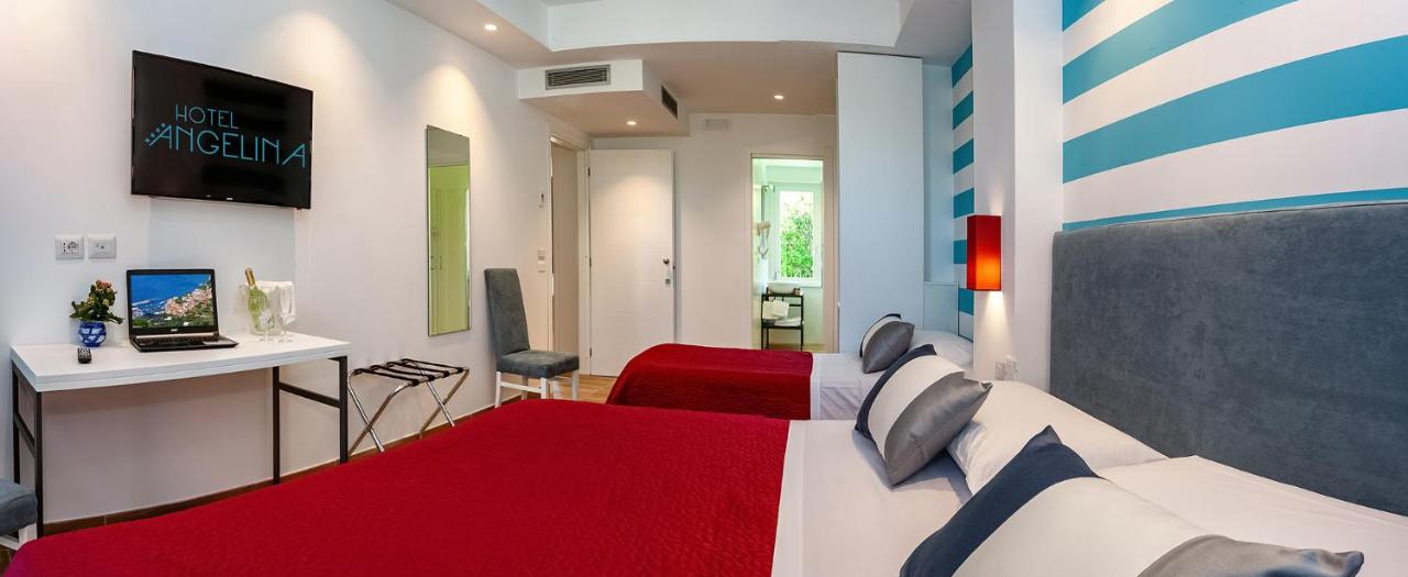 een slaapkamer met twee bedden en een televisie erin. bij Hotel Angelina in Sant'Agnello