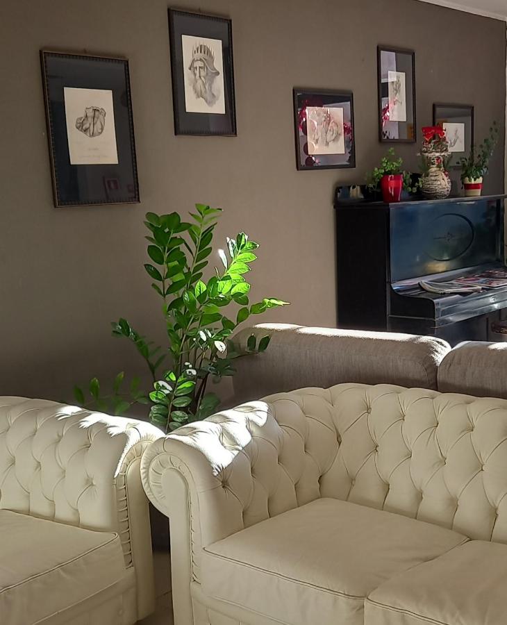 een woonkamer met een witte bank en een plant bij Hotel Aniene in Rome