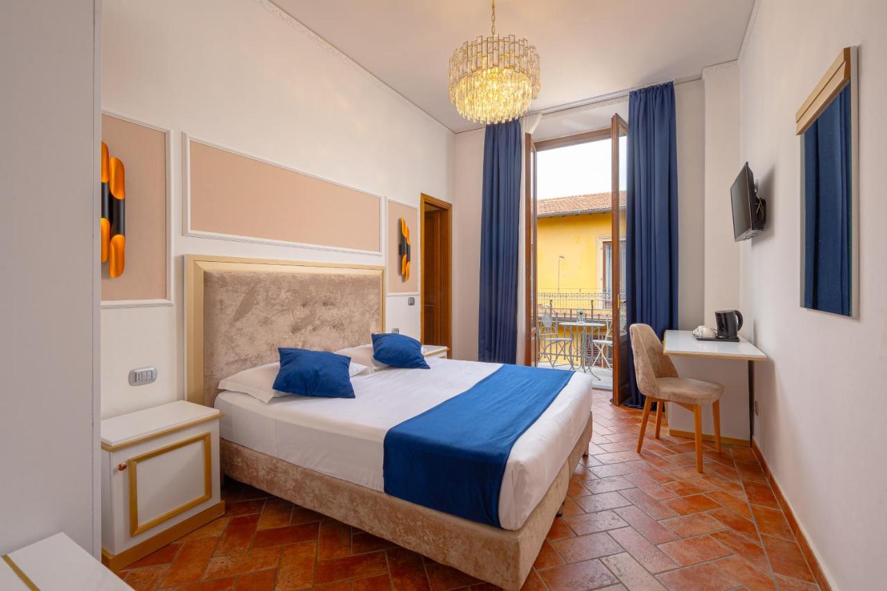 een slaapkamer met een bed en een kroonluchter bij Hotel Annabella Roof Terrace in Florence