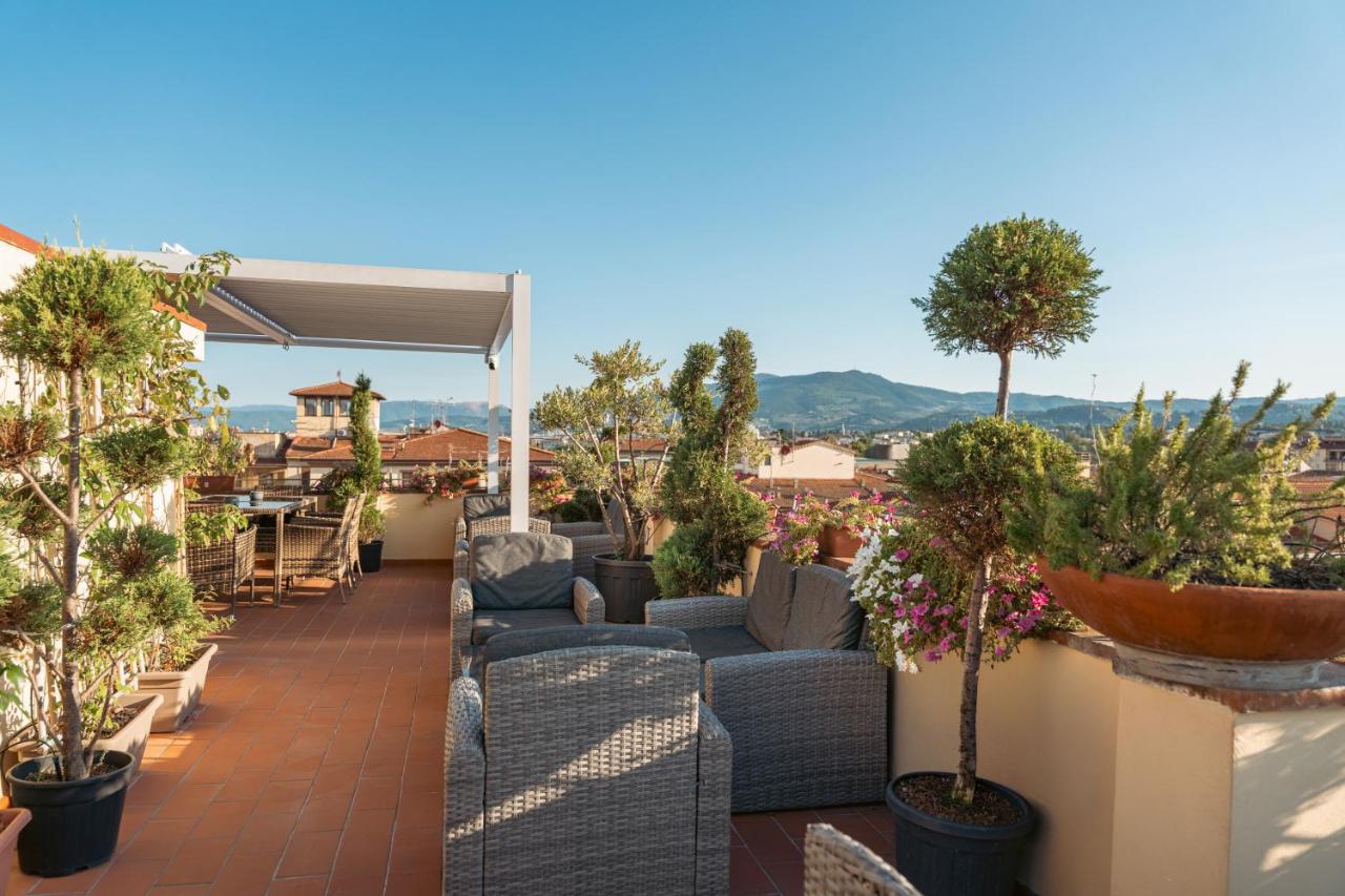 een terras met banken en bomen op een dak bij Hotel Annabella Roof Terrace in Florence