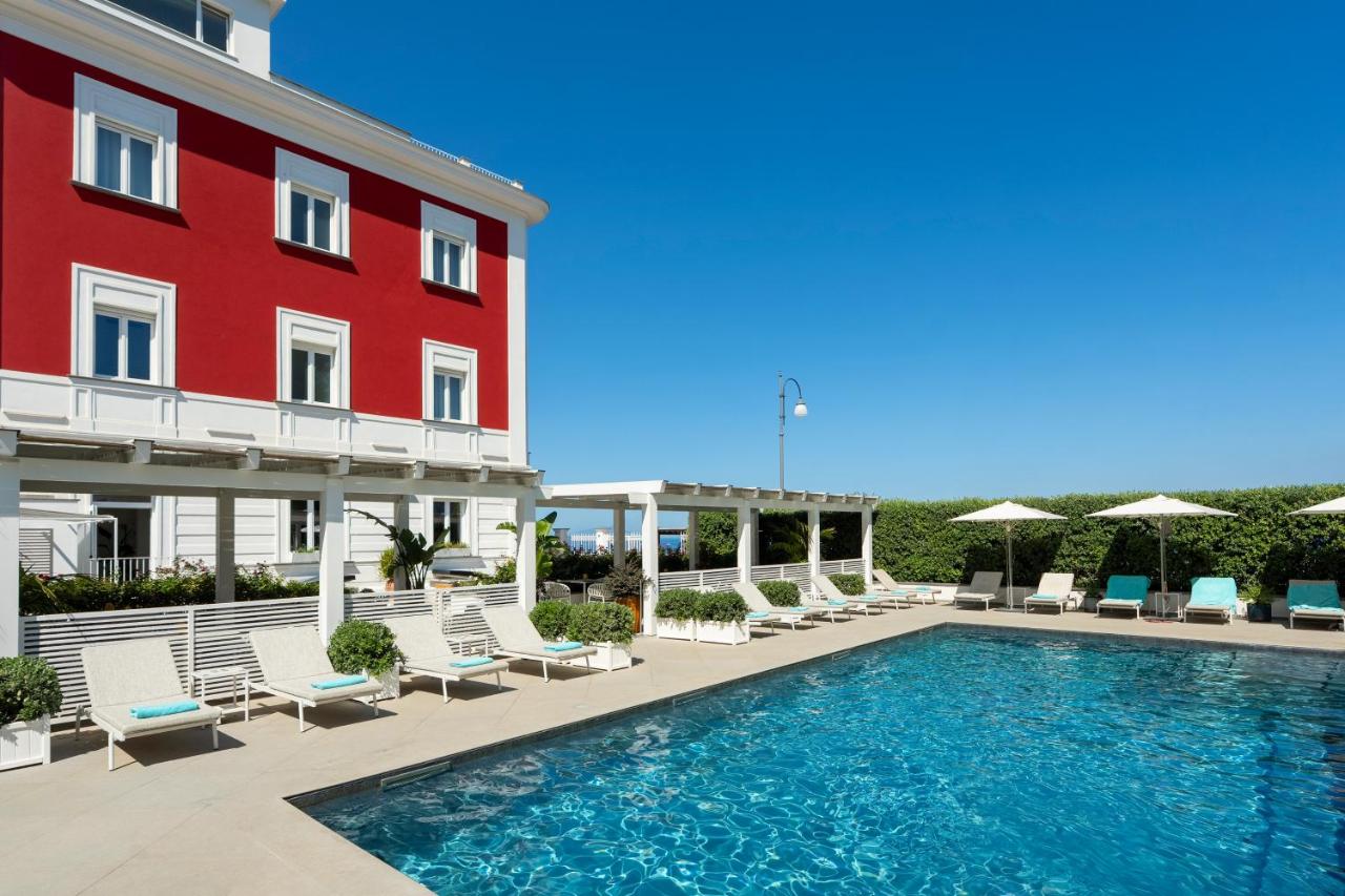 een hotel met zwembad naast een rood gebouw bij Hotel Villa Garden in Sant'Agnello