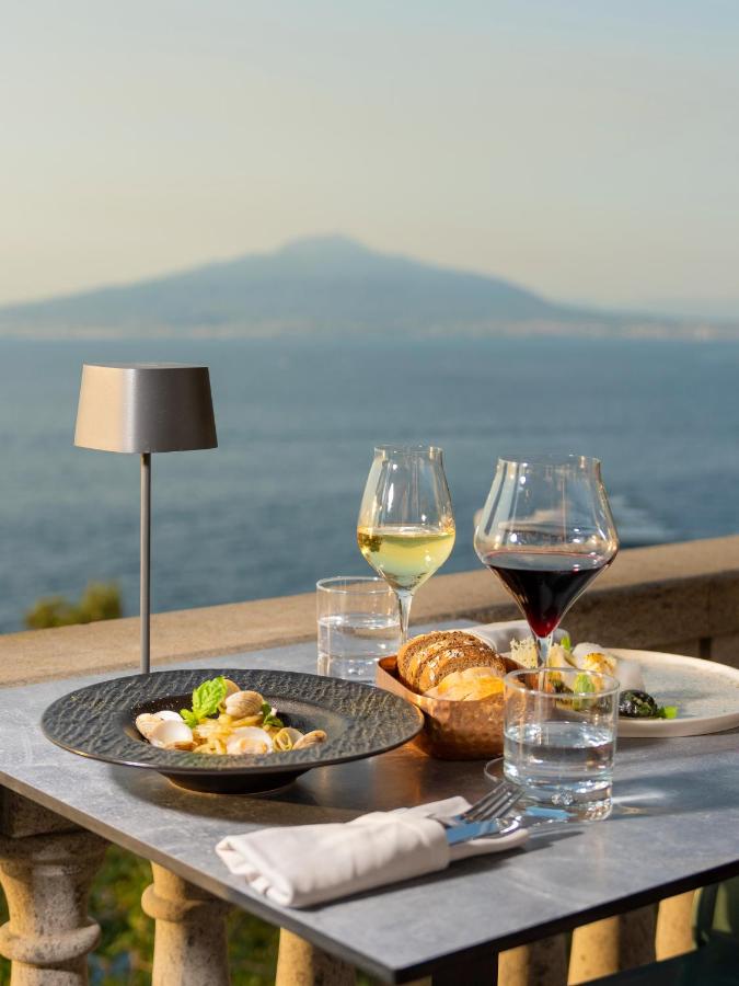 een tafel met twee borden eten en wijnglazen bij Hotel Villa Garden in Sant'Agnello