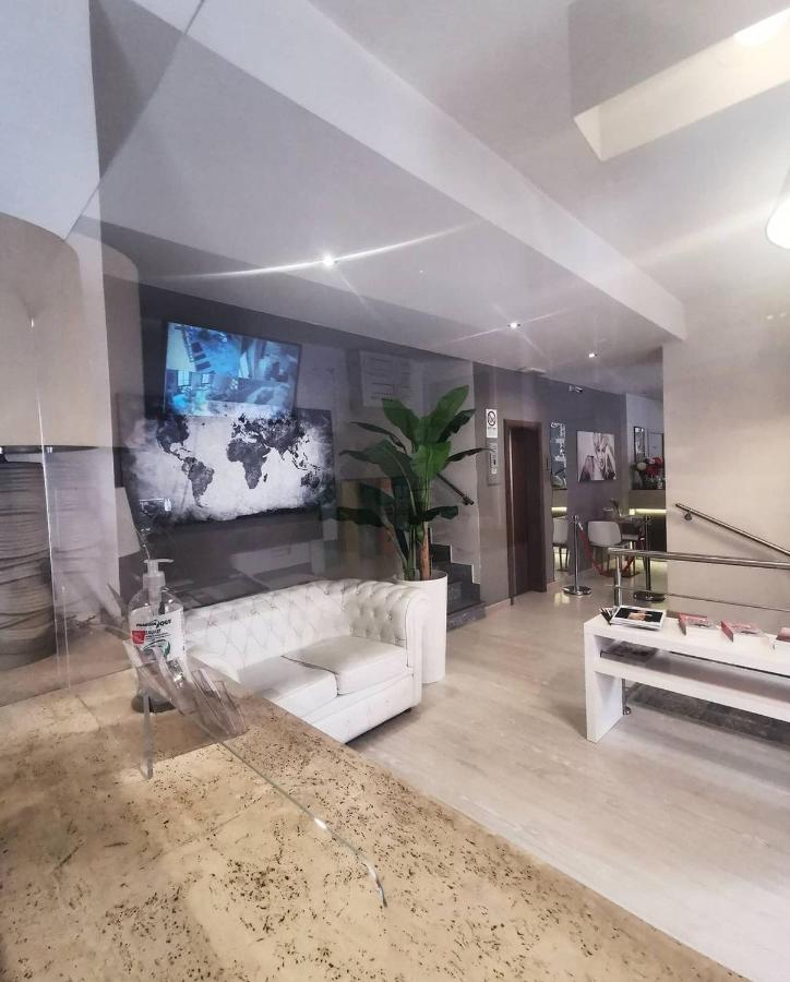 een woonkamer met een witte bank en een tv bij Hotel Ares Milano in Milaan