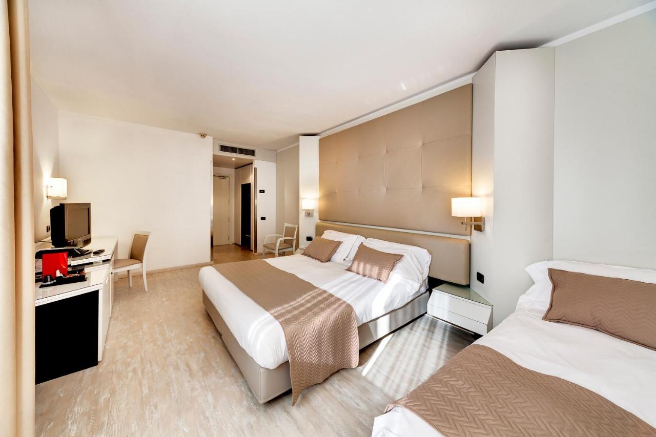 een hotelkamer met twee bedden en een bureau bij Mediterraneo Palace Hotel in Ragusa