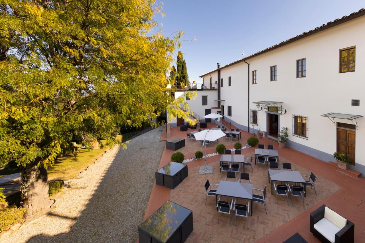 Een bovenaanzicht van een binnenplaats met tafels en stoelen. bij Villa Castiglione in Impruneta