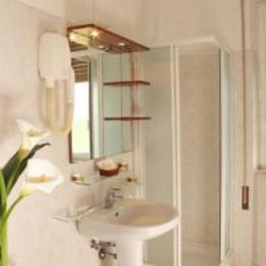 een witte badkamer met een wastafel en een douche bij Hotel Cassia in Rome