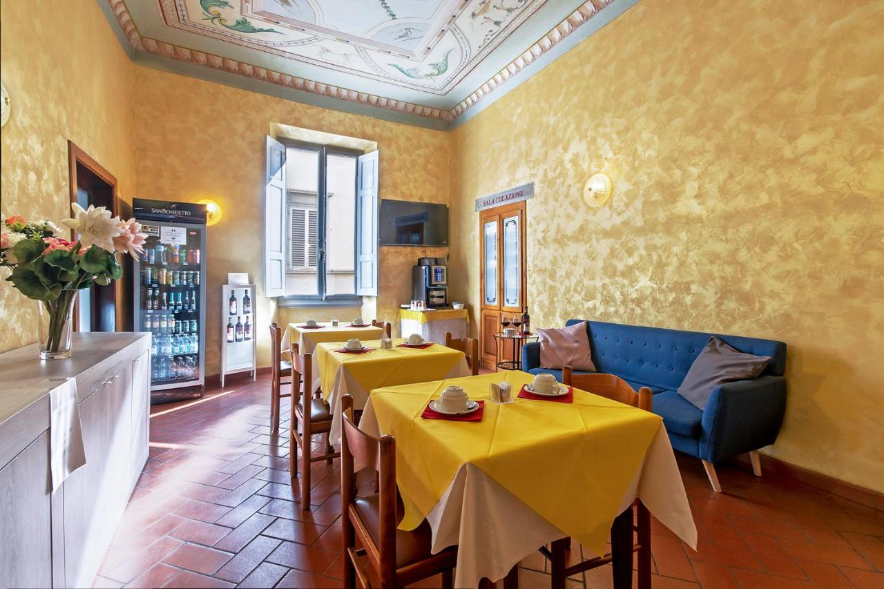 een restaurant met tafels en stoelen en gele muren bij Hotel Costantini in Florence