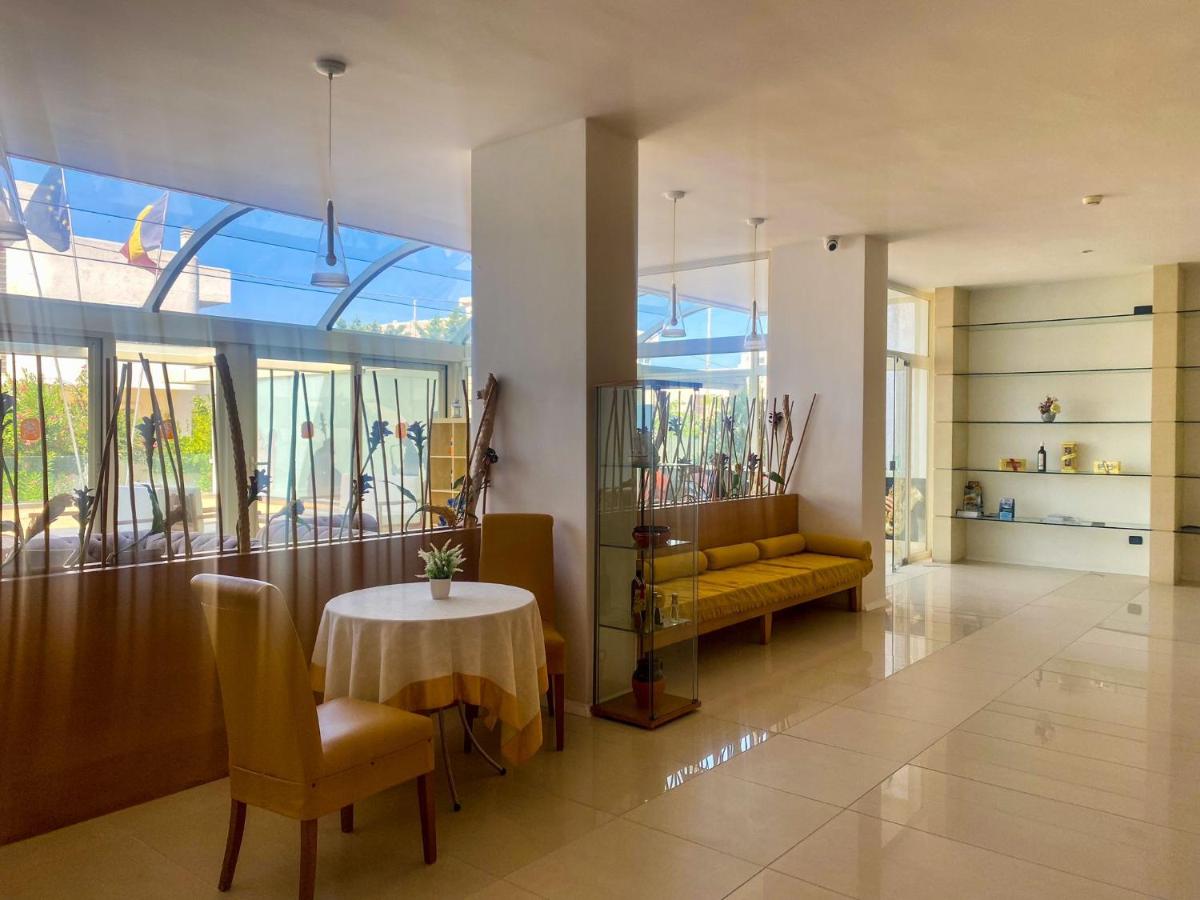 een woonkamer met een tafel en een gele bank bij Hotel Degli Haethey in Otranto