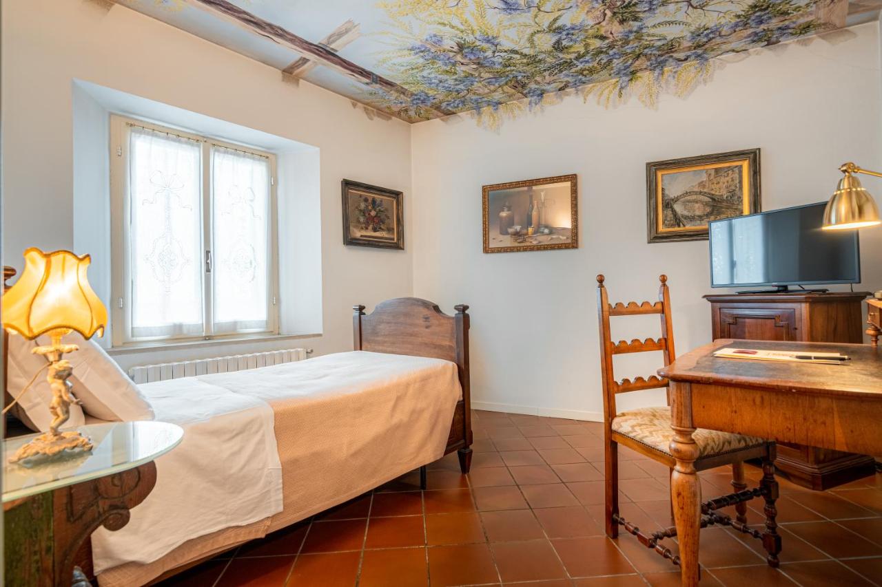 een slaapkamer met een bed, een bureau en een televisie bij Hotel Della Porta in Santarcangelo di Romagna