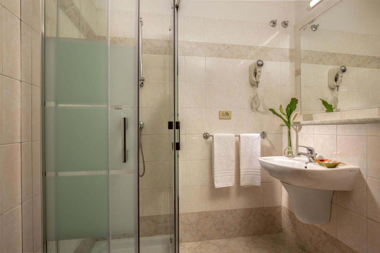 een badkamer met een glazen douche en een wastafel bij Hotel Dorica in Rome