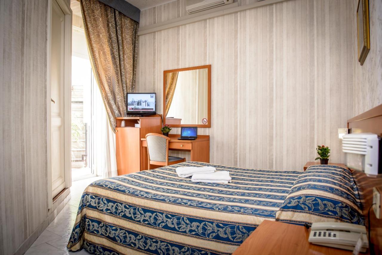 een hotelkamer met een bed, een bureau en een raam bij Hotel Emmaus in Rome