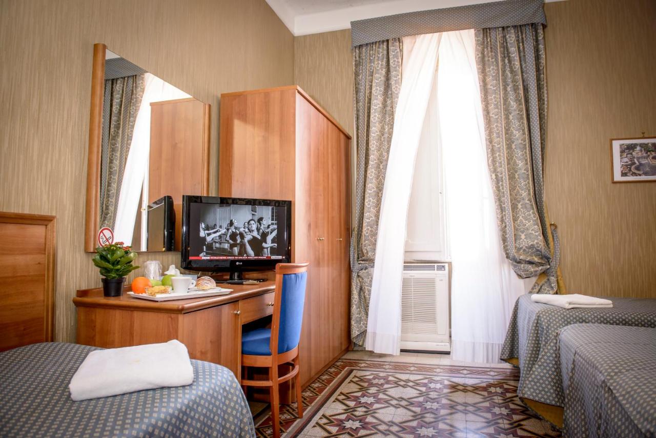 een hotelkamer met een bureau met een televisie en een bed bij Hotel Emmaus in Rome