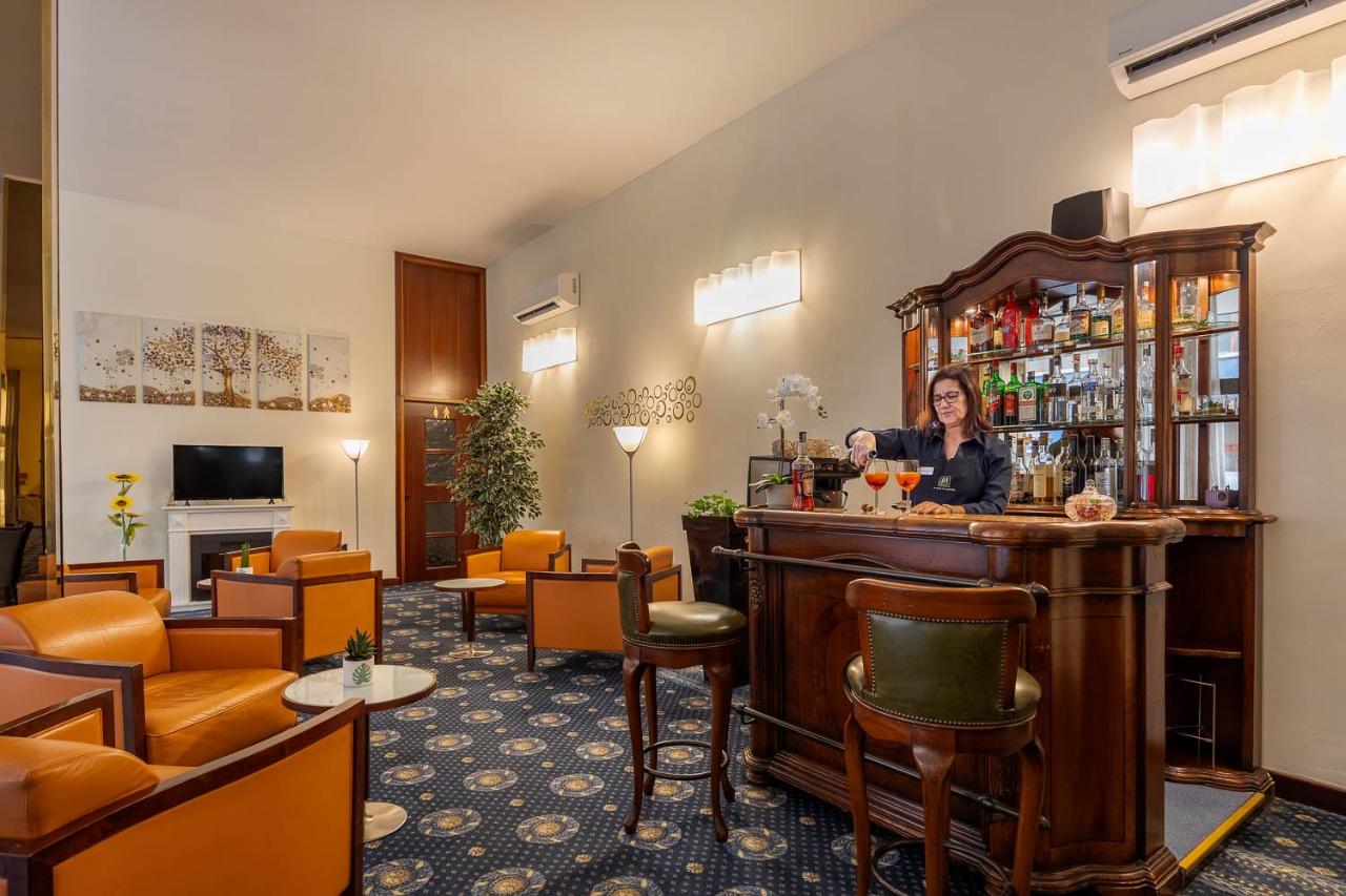 een vrouw staat aan de bar in de lobby van een hotel bij iH Hotels Milano Eur - Trezzano sul Naviglio in Trezzano sul Na