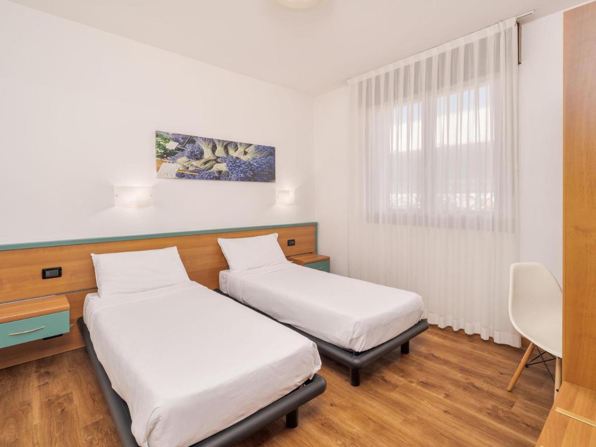een kamer met twee bedden en een raam bij B&B HOTEL Eurorest Conegliano in Conegliano