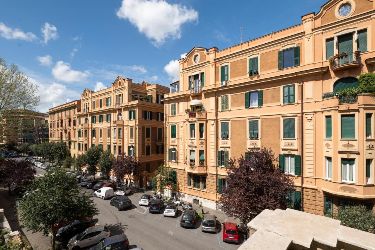 een stadsstraat met auto's geparkeerd voor gebouwen bij Sky Blue Place Rome in Rome