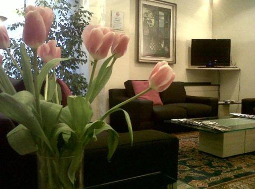 een vaas met roze bloemen in een woonkamer bij Hotel Giovanni in Padua