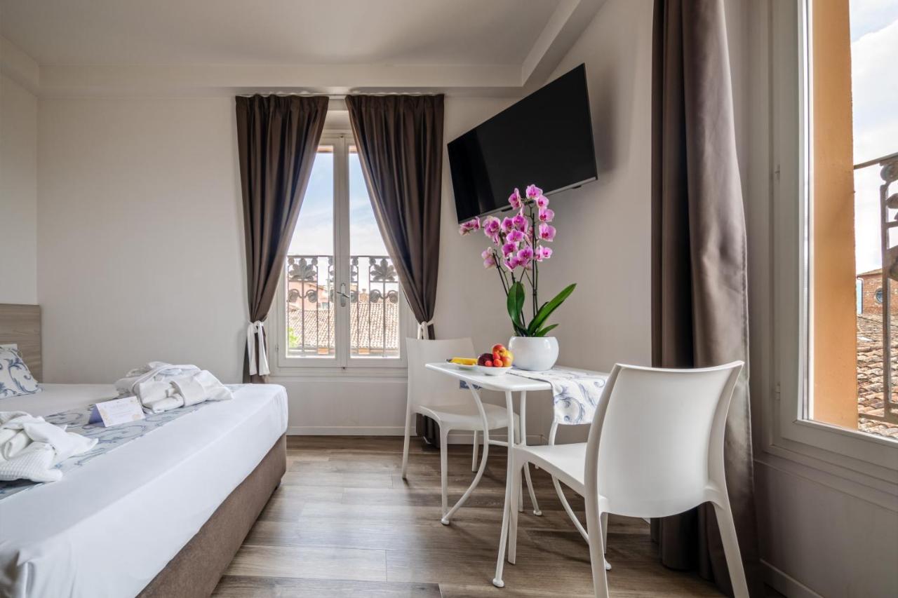 een slaapkamer met een bed, een tafel en stoelen bij Albergo La Rocca in Brisighella