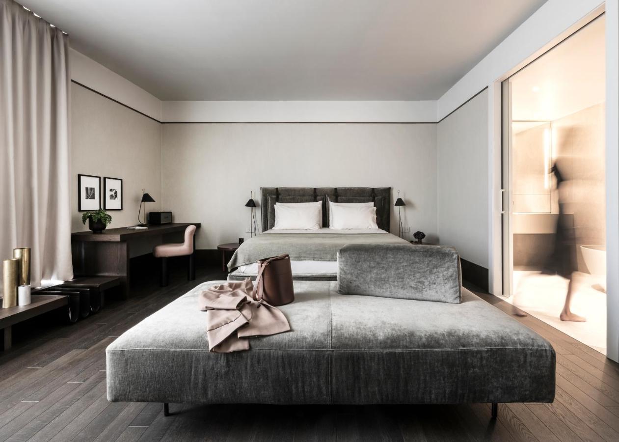 een slaapkamer met een bed en een bank bij Litta Palace Milano Urban Resort in Lainate