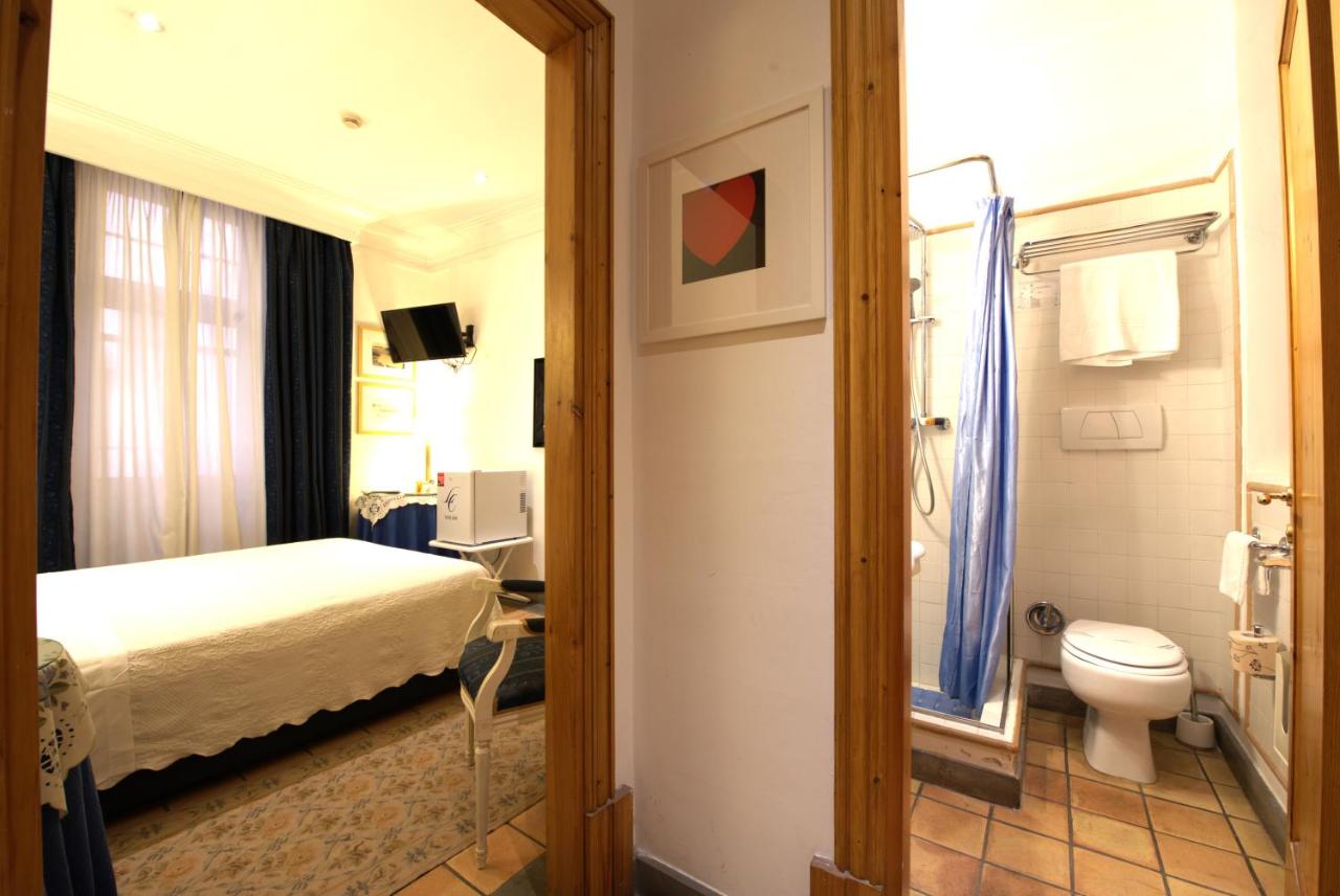 een hotelkamer met een bed en een toilet bij Hotel Locanda Cairoli in Rome