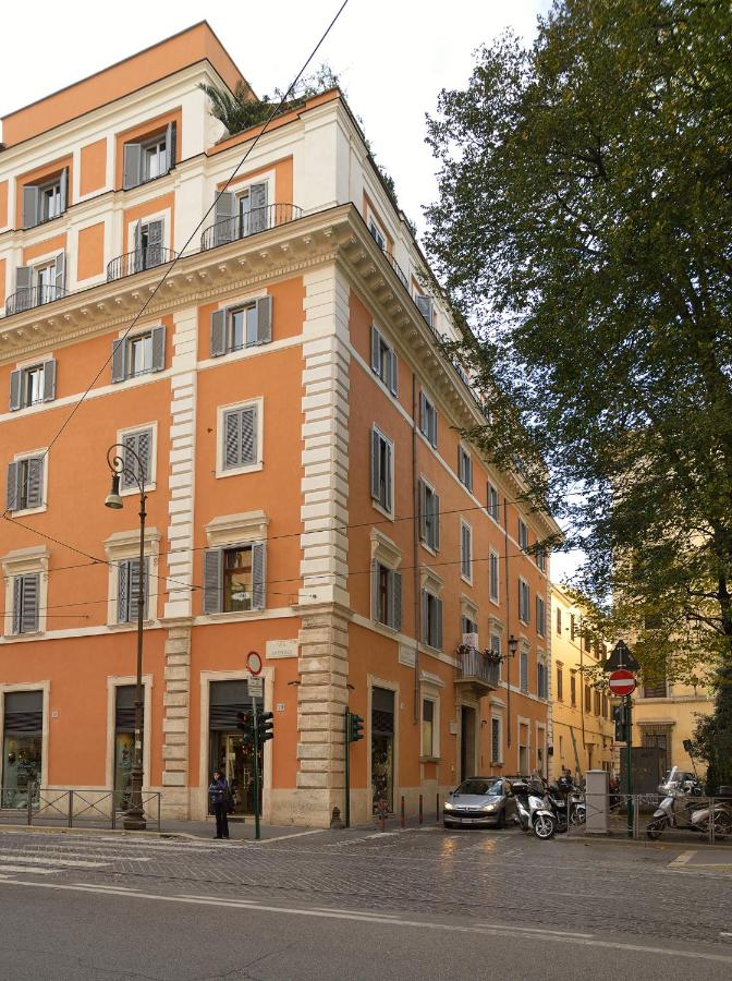 een groot oranje gebouw met een auto ervoor geparkeerd bij Hotel Locanda Cairoli in Rome