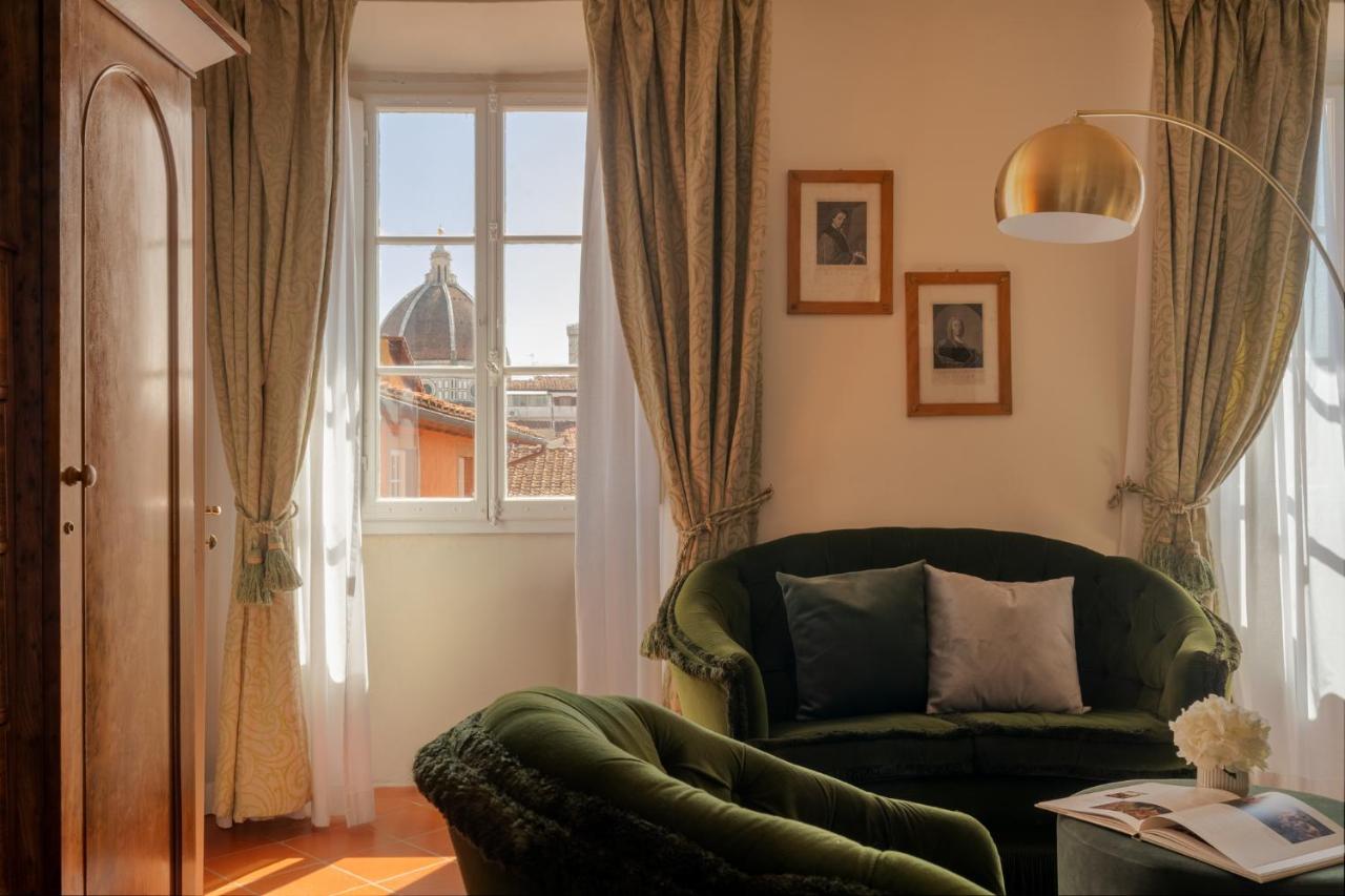 een woonkamer met een groene bank en een raam bij Loggiato Dei Serviti in Florence