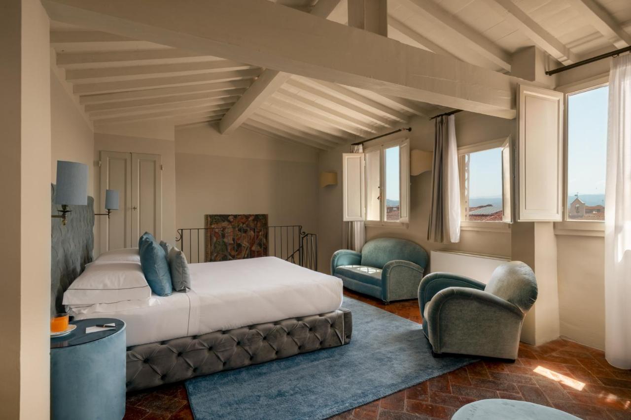 een slaapkamer met een bed en twee stoelen bij Loggiato Dei Serviti in Florence