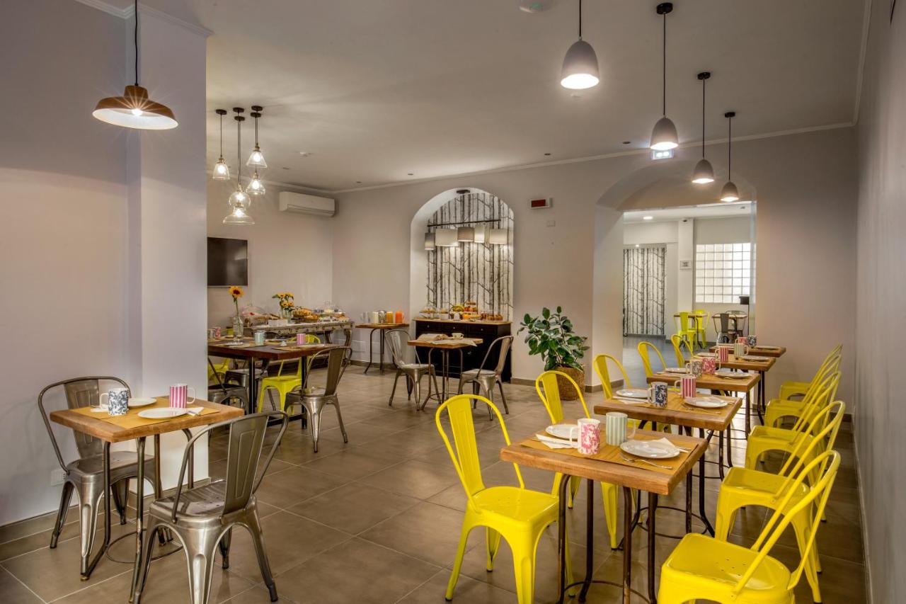 een restaurant met gele stoelen en tafels in een kamer bij Urban Garden Hotel in Rome