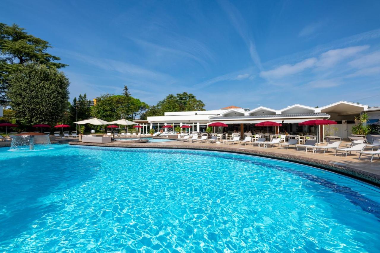 een groot zwembad met ligstoelen en parasols bij Hotel Mioni Royal San in Montegrotto Terme