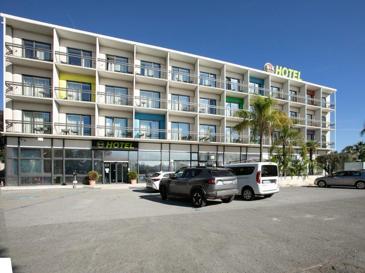 een hotel met auto's geparkeerd op een parkeerplaats bij B&B Hotel Savona in Savona