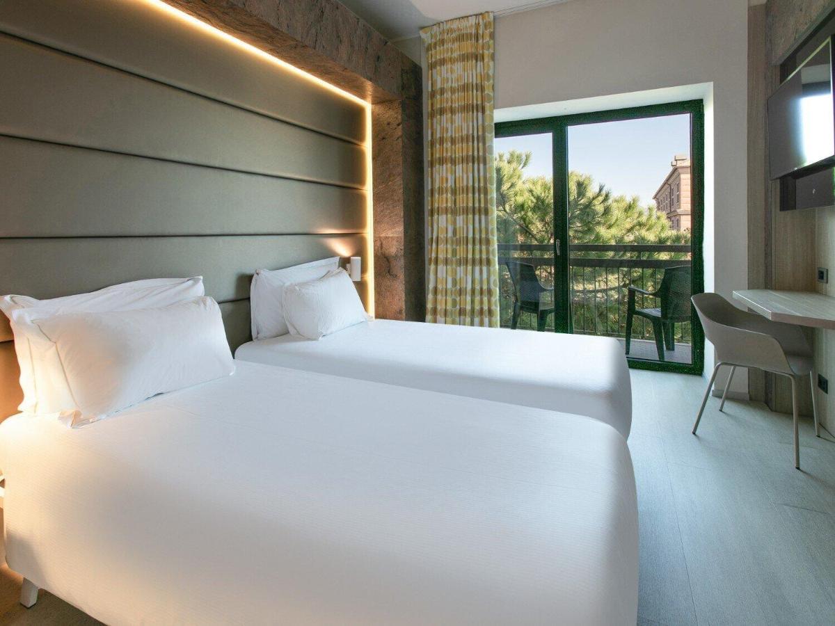 een groot wit bed in een kamer met balkon bij B&B Hotel Savona in Savona