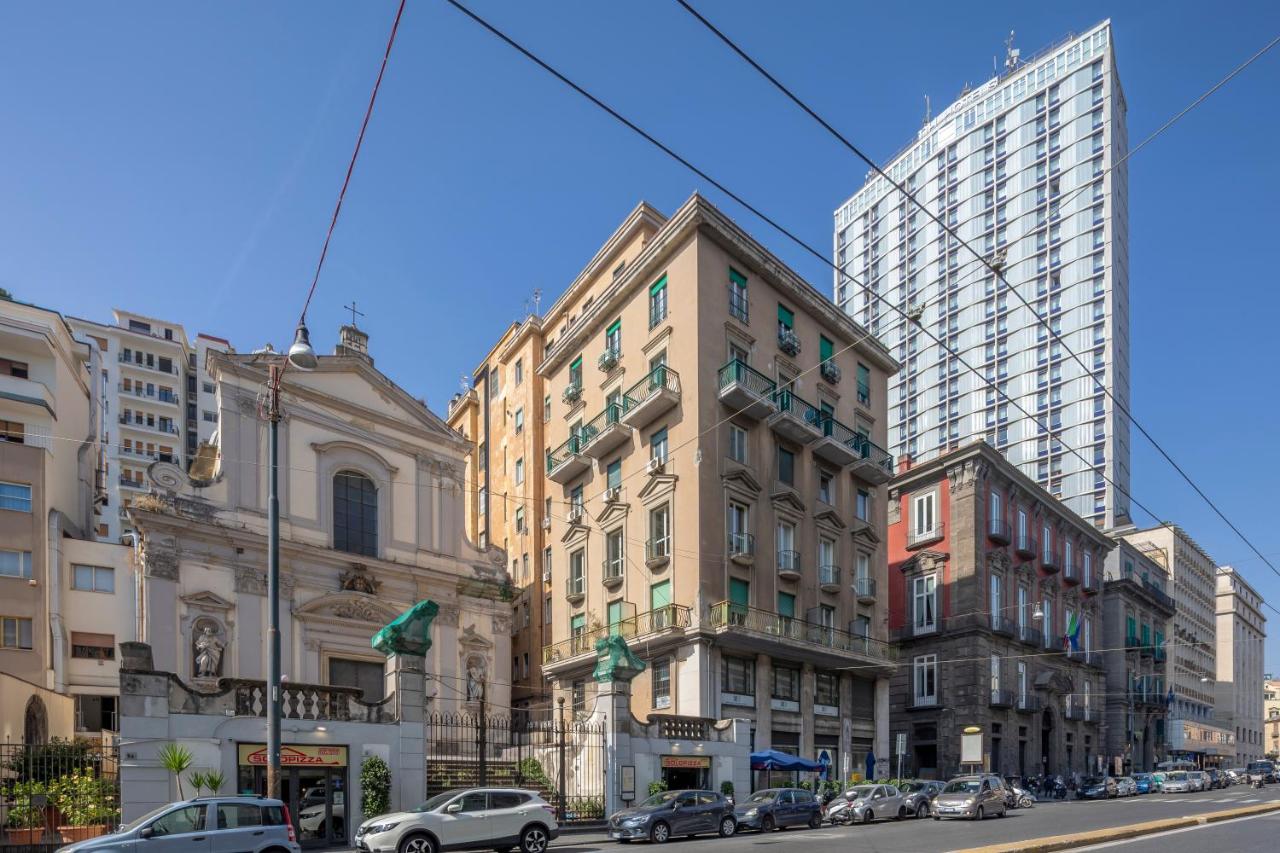 een stadsstraat met auto's geparkeerd voor gebouwen bij Napolit'amo Hotel Medina in Napels