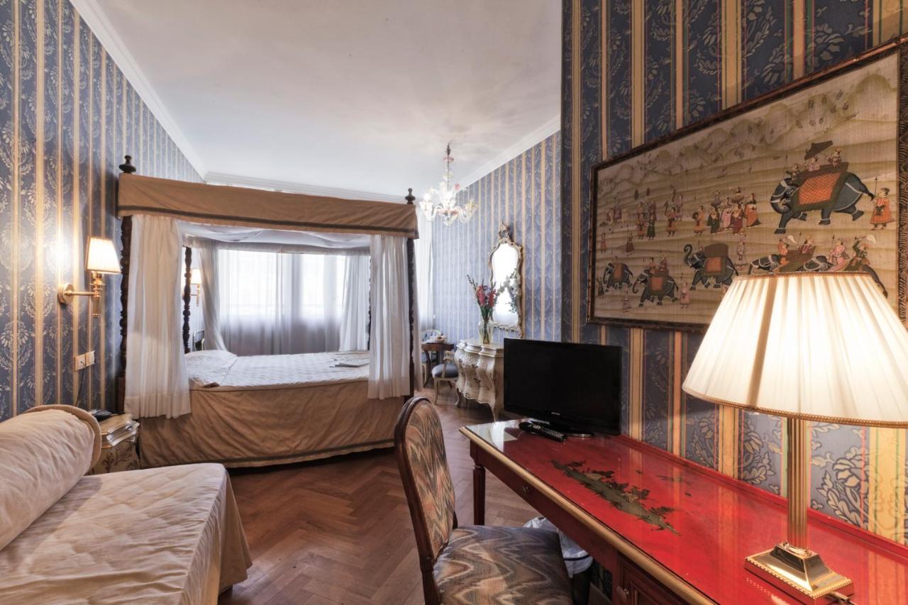 een woonkamer met een bed en een tafel met een lamp bij Palazzo Cendon Piano Antico in Venetië