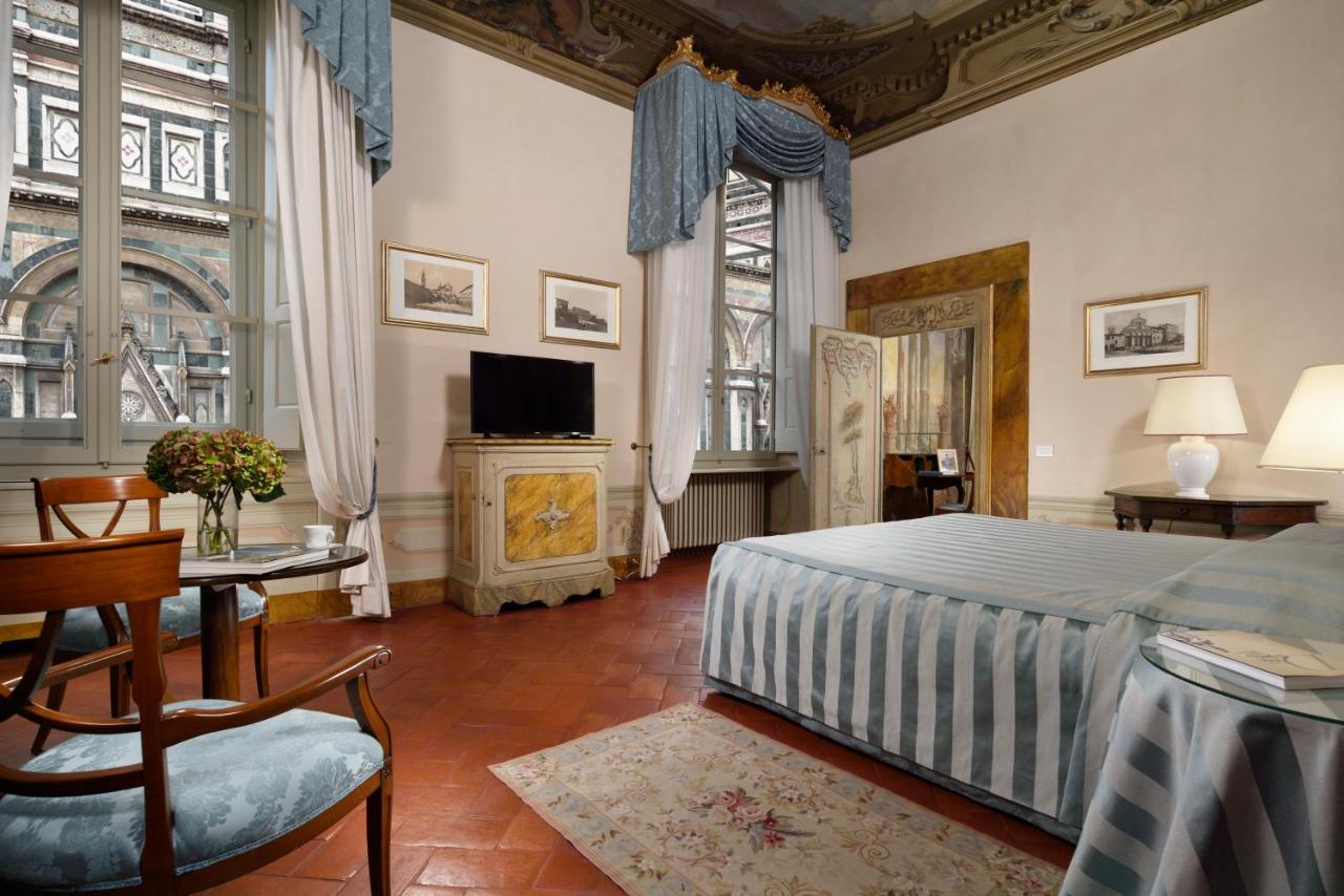 een slaapkamer met een bed en een tv erin bij Palazzo Niccolini al Duomo Residenza D'Epoca in Florence