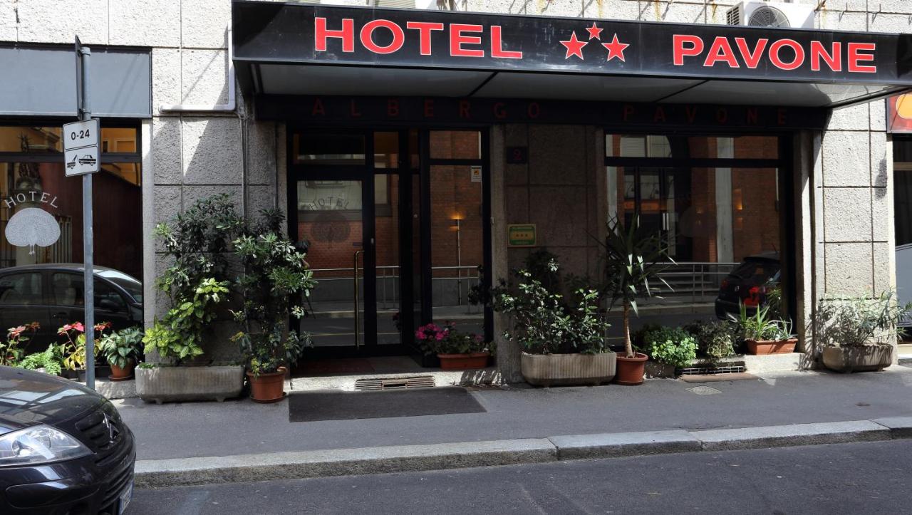 een hotelingang met potplanten ervoor. bij Hotel Pavone in Milaan