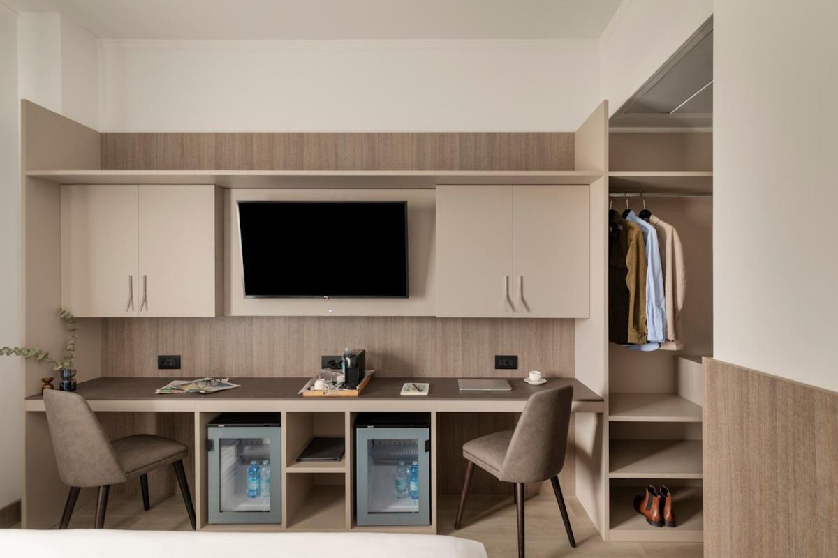 een keuken met een bureau met twee stoelen en een tv bij Living Hotel Milano in Cornaredo