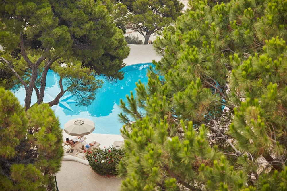 Zwembad omringd door palmbomen — Forte Village - Hotel Le Palme