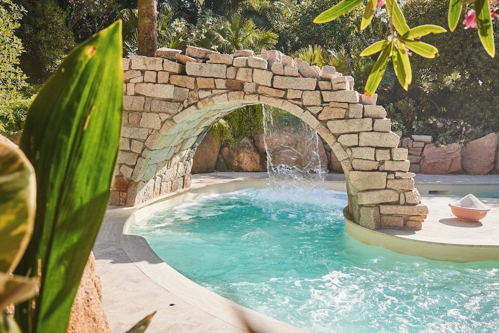Zwembad omringd door palmbomen — Forte Village - Hotel Le Palme