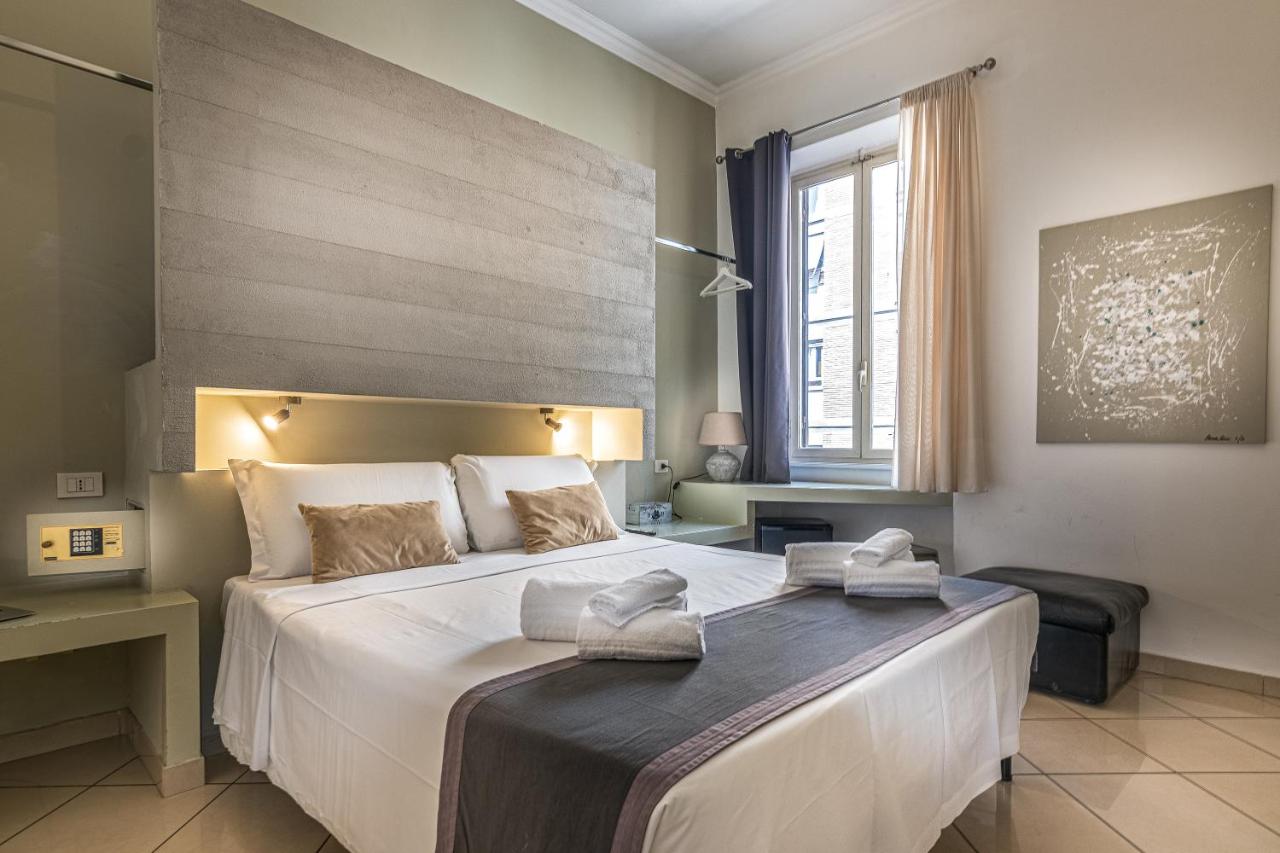 een slaapkamer met een groot bed waarop twee handdoeken liggen bij Crossroad Hotel in Rome