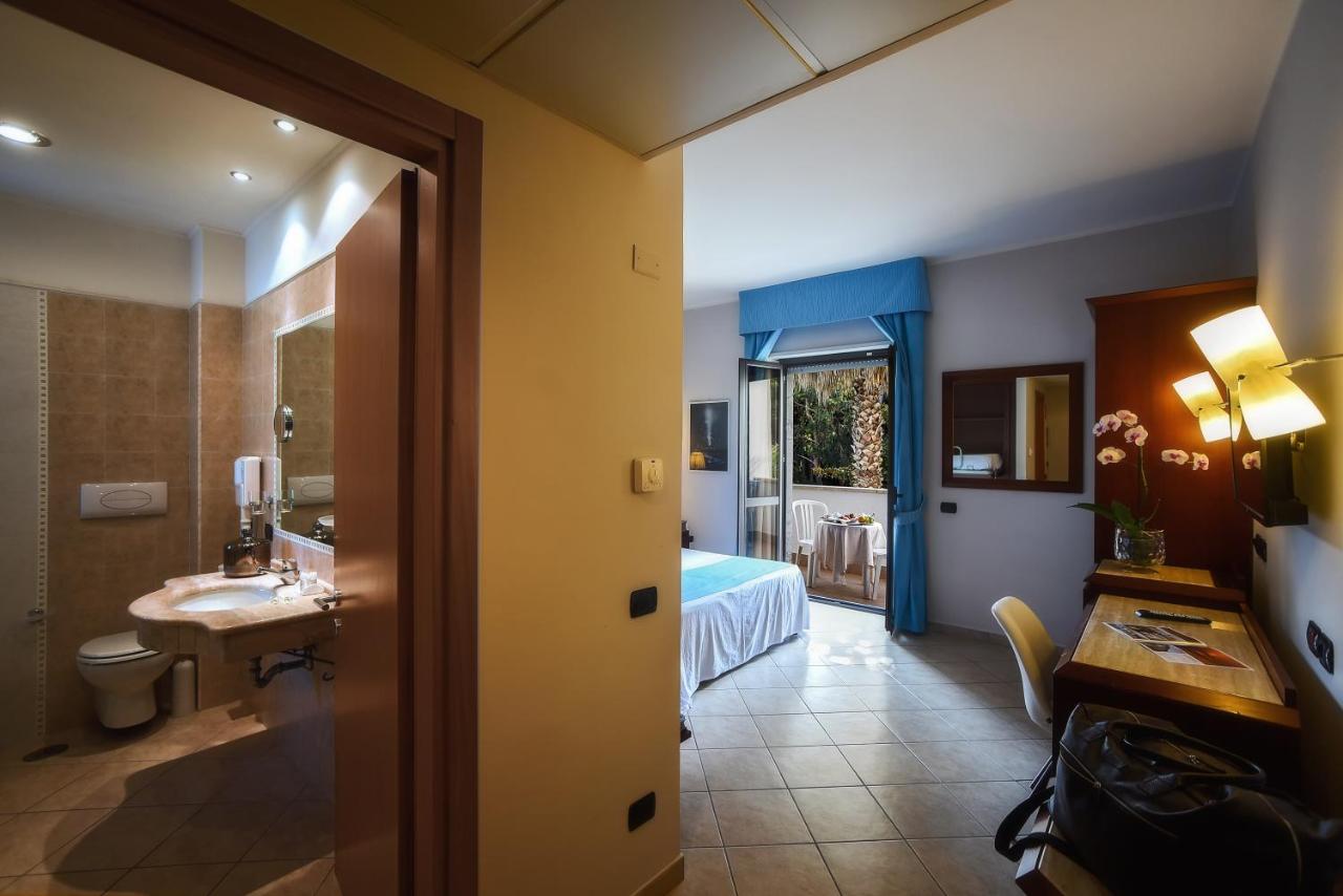 een hotelkamer met een badkamer met een wastafel en een bed bij Hotel Le Palme in Paestum