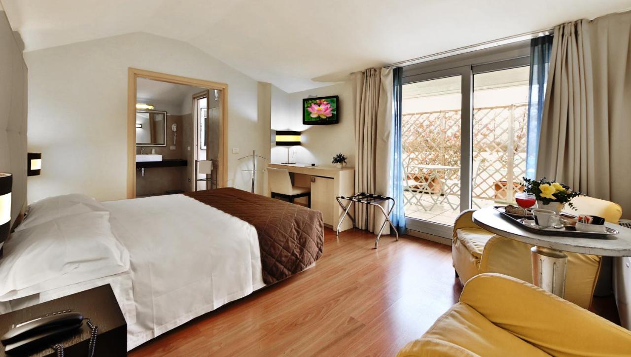 een hotelkamer met een bed, een bureau en een raam bij Regal Hotel in Brescia