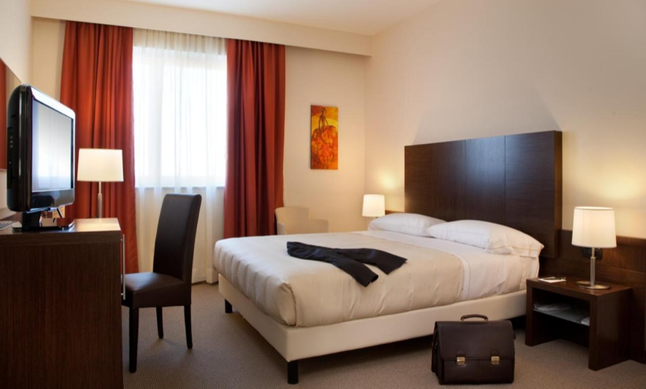 een hotelkamer met een bed en een flatscreen-tv bij Torino Hotel San Luigi - Ristorante Trait d'Union in Beinasco